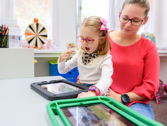 child and adult using tablet for communication